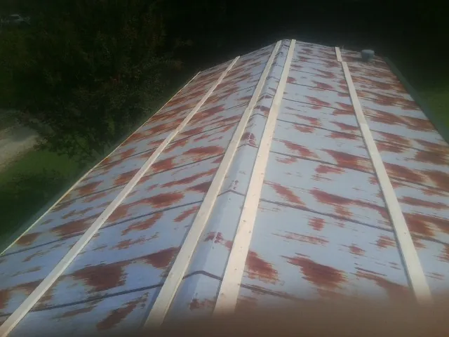 Rusted metal roof panels with new wood purlins before replacement — Storm Damage Roof Repair in Campaign by Roofing Brothers