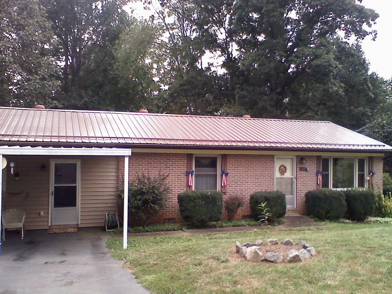 Bronze metal roof and carport on a brick ranch home — Roof Repair work by our crew in Campaign